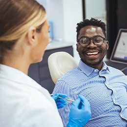 Dentist and patient smiling at each other during visit