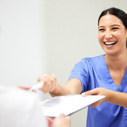 a dental assistant helping a patient sign up for a payment plan