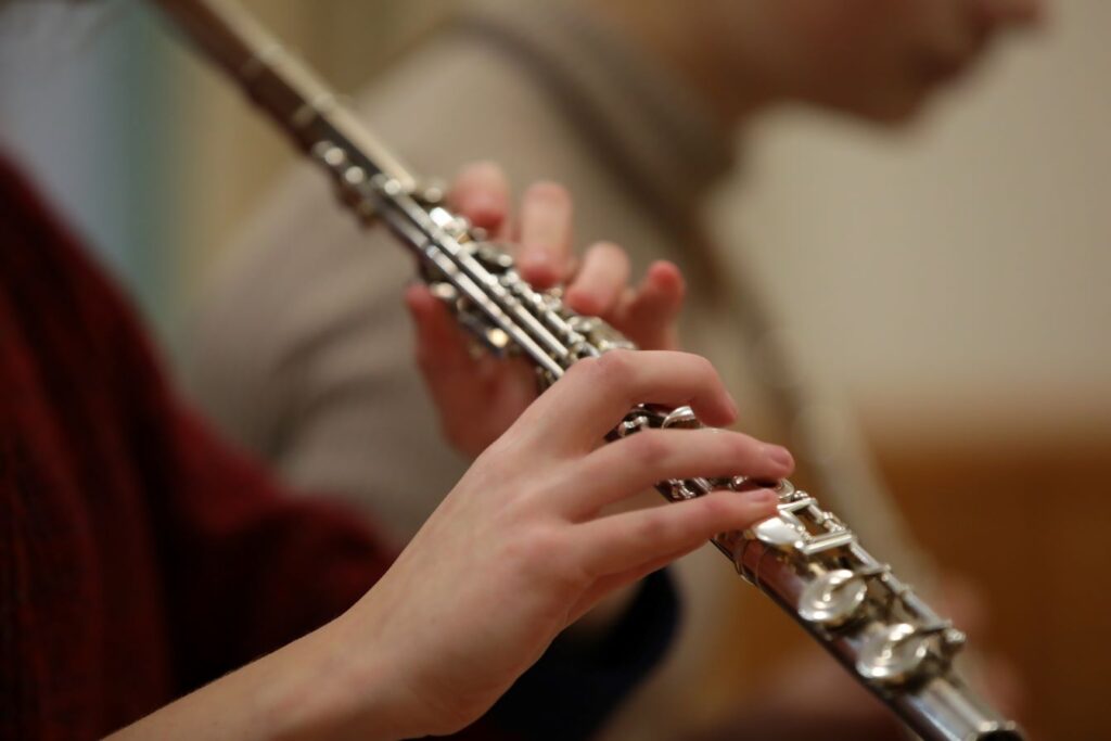 A teen playing a wind instrument.